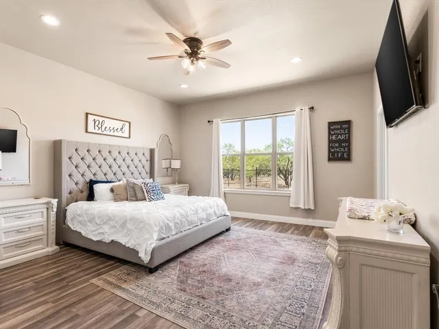 a bedroom with a large bed and a flat screen tv