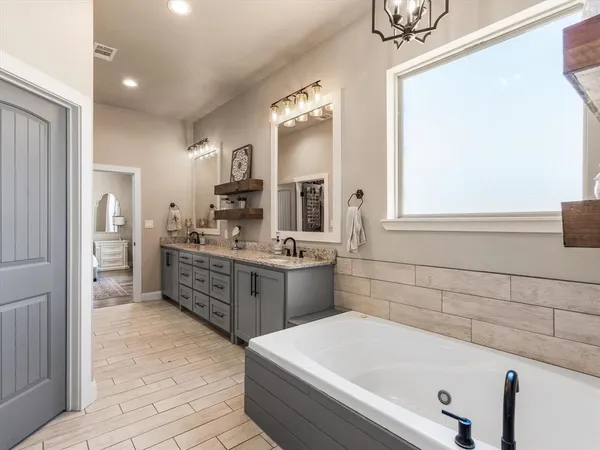 a large bathroom with a tub sink shower and mirror