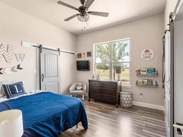 a bedroom with a bed window and a flat screen tv