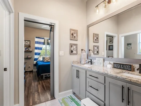 a en suite bathroom with a granite countertop sink and a mirror