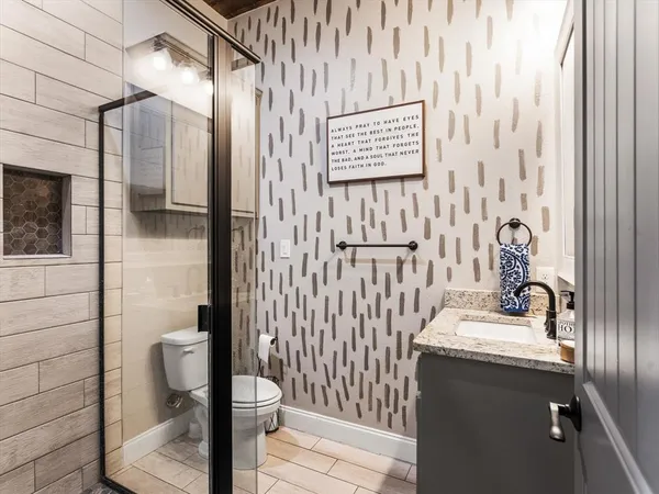 a bathroom with a sink a toilet and shower