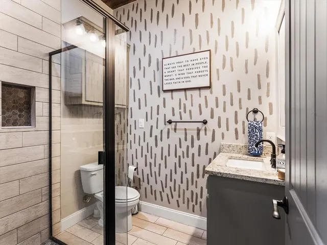 a bathroom with a sink a toilet and shower