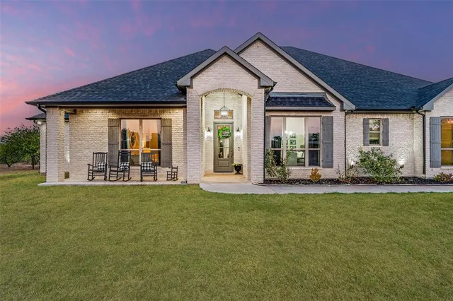 a front view of a house with a garden and yard