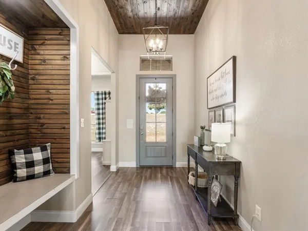 a view of hallway with wooden floor and chandelier