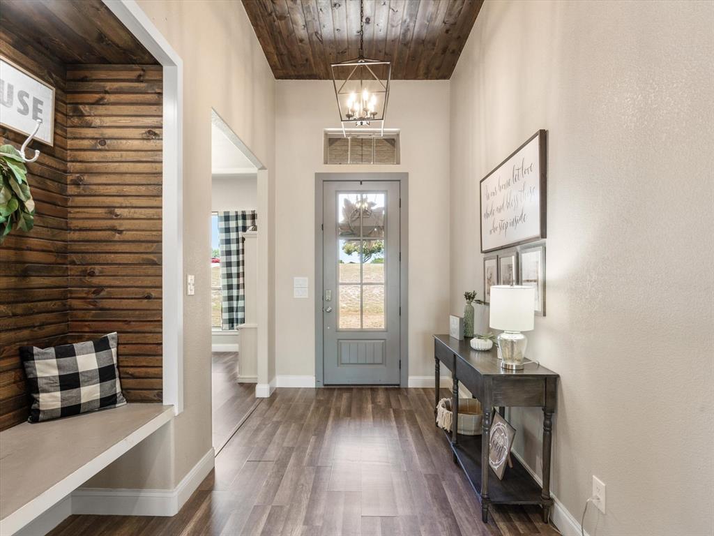 101 Trail Ridge Weatherford, TX 76087 - Photo 4 of 39 a view of hallway with wooden floor and chandelier