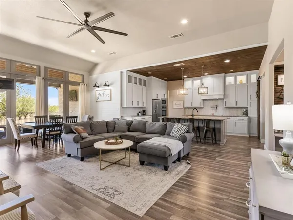 a living room with lots of furniture and view of kitchen