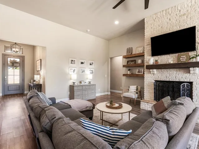 a living room with furniture a flat screen tv and a fireplace