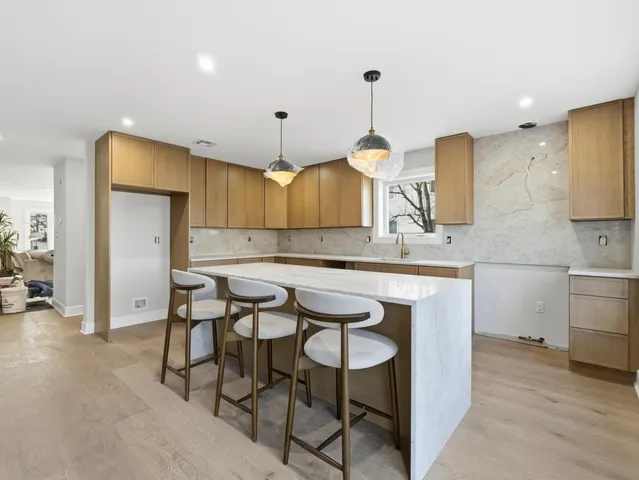 a kitchen with a table chairs refrigerator and wooden cabinets