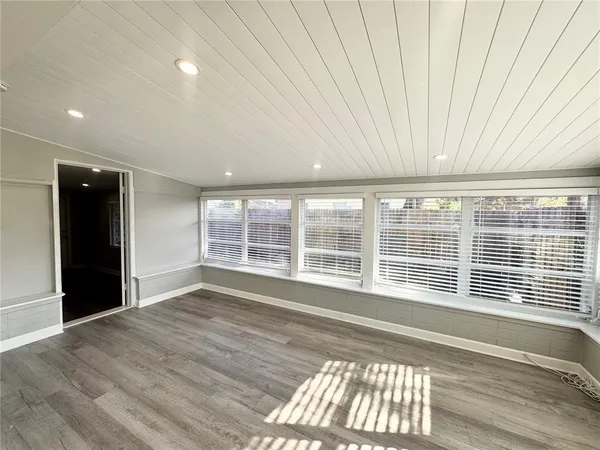 a view of a room with wooden floor and a window
