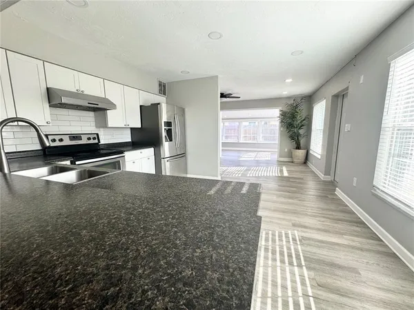 a kitchen with stainless steel appliances granite countertop a sink stove and cabinets