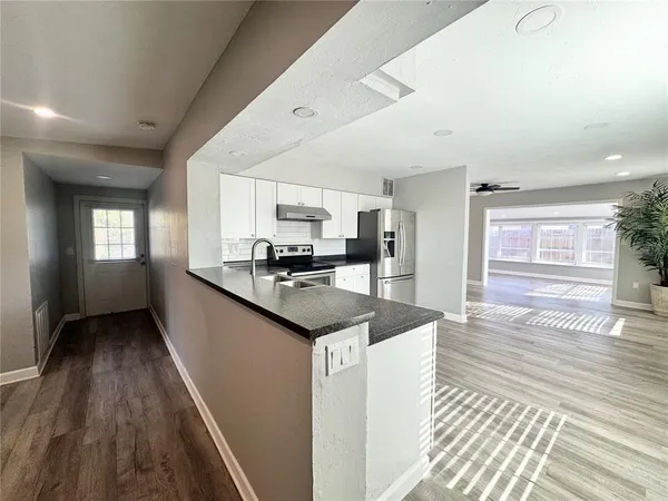 a room with a sink a mirror and a window