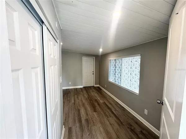 a view of a kitchen with fridge and wooden floor