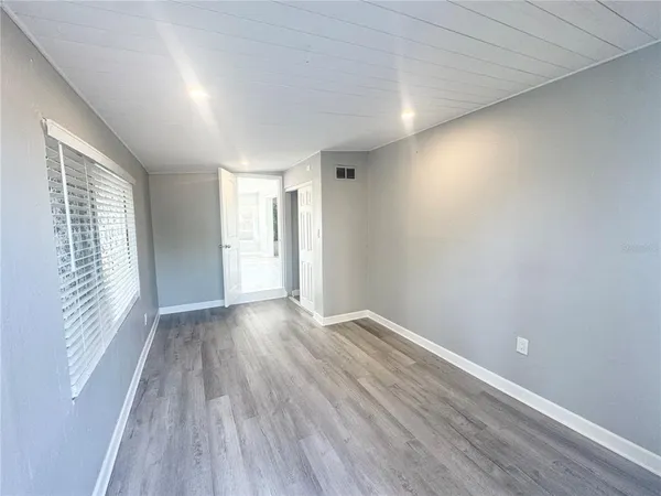 a view of empty room with wooden floor