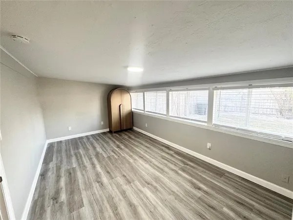a view of a room with wooden floor and windows