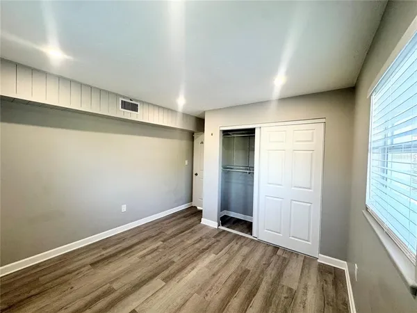 a view of a house with a yard and a large tree
