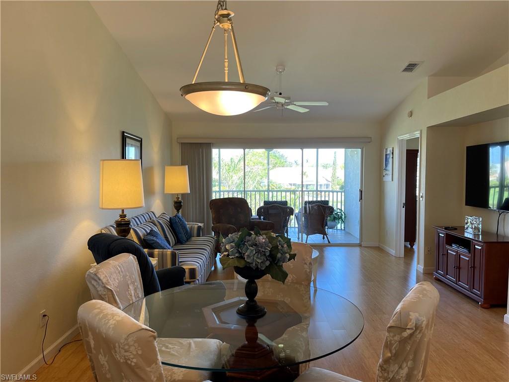 9009 Michael Circle, Unit 1110 Naples, FL 34113 - Photo 13 of 48 a living room with furniture a chandelier and a chandelier