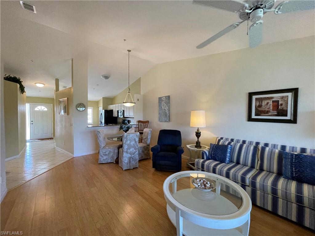 9009 Michael Circle, Unit 1110 Naples, FL 34113 - Photo 14 of 48 a living room with furniture and a chandelier