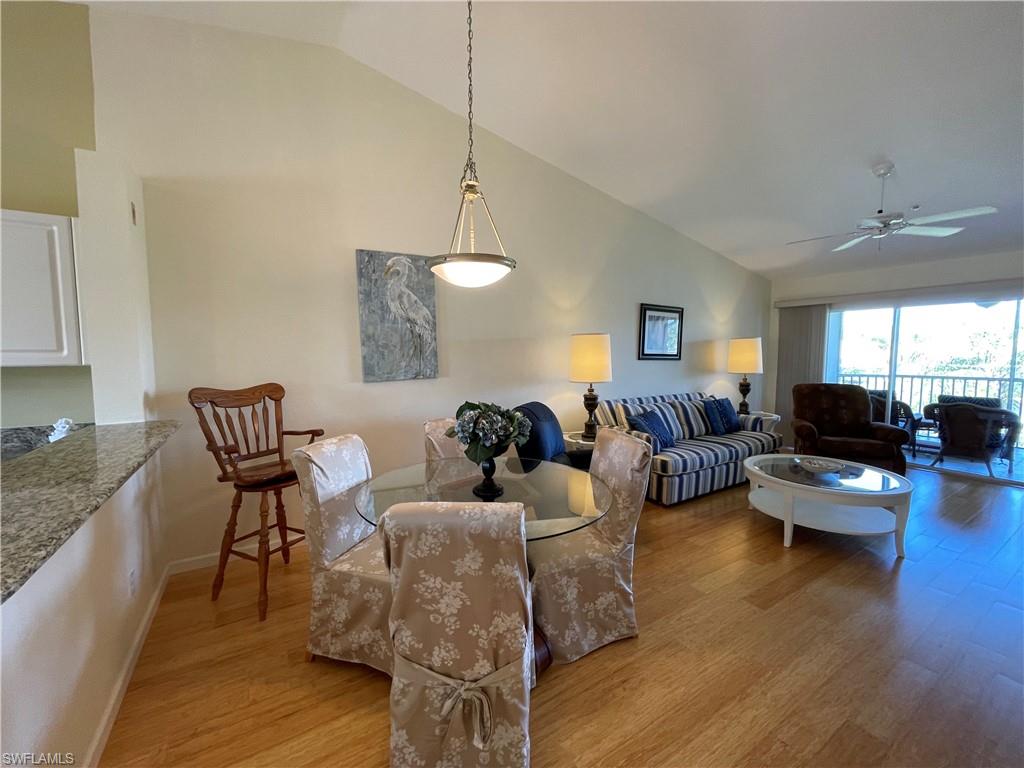9009 Michael Circle, Unit 1110 Naples, FL 34113 - Photo 16 of 48 a living room with furniture wooden floor and a chandelier