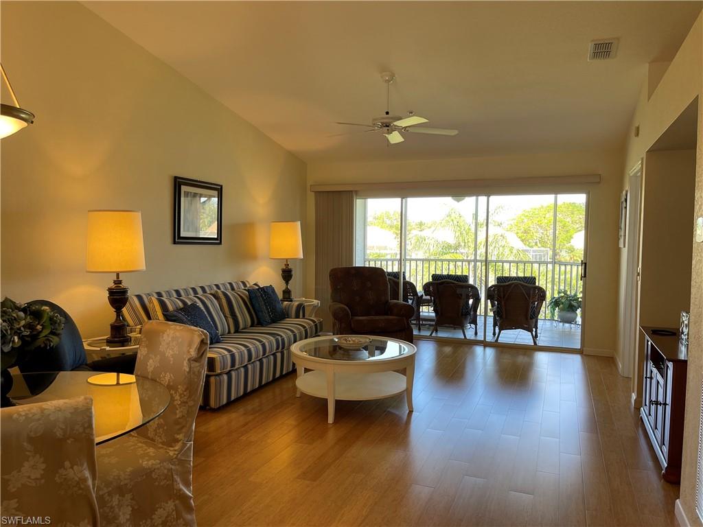 9009 Michael Circle, Unit 1110 Naples, FL 34113 - Photo 17 of 48 a living room with furniture a flat screen tv and a large window