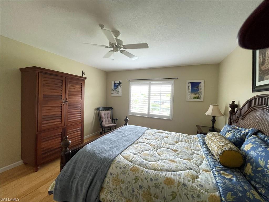 9009 Michael Circle, Unit 1110 Naples, FL 34113 - Photo 21 of 48 a bedroom with a bed and a chandelier