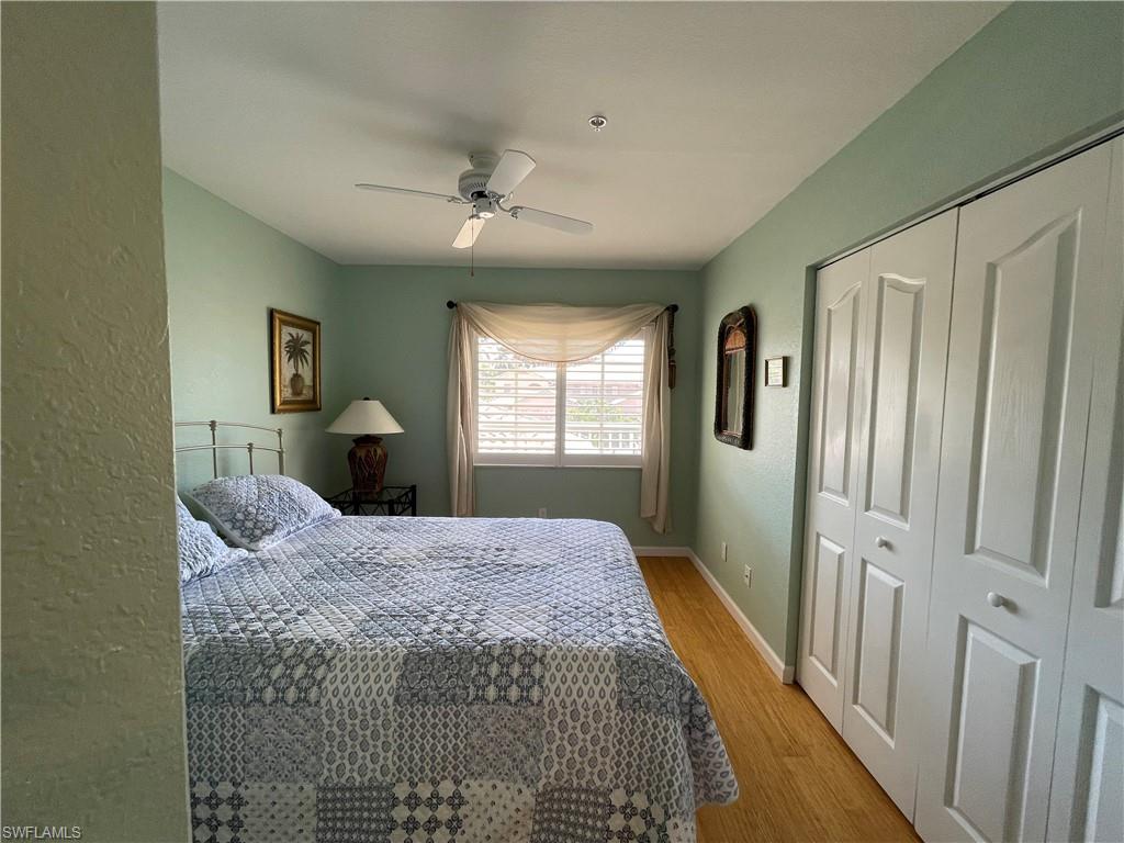 9009 Michael Circle, Unit 1110 Naples, FL 34113 - Photo 28 of 48 a bedroom with a large bed and a chandelier