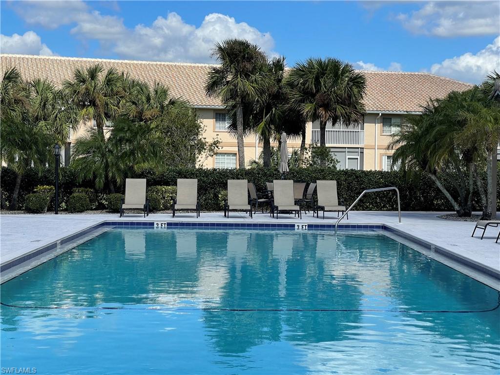 9009 Michael Circle, Unit 1110 Naples, FL 34113 - Photo 35 of 48 a view of a swimming pool with a table and chairs