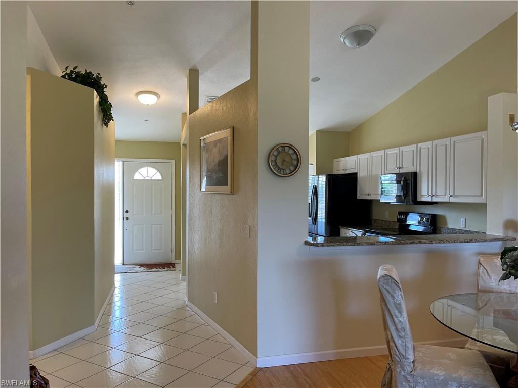 9009 Michael Circle, Unit 1110 Naples, FL 34113 - Photo 8 of 48 a kitchen with stainless steel appliances granite countertop a refrigerator and microwave