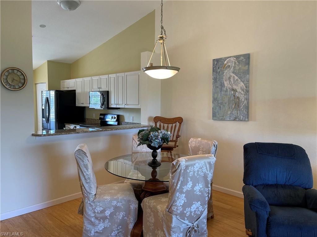 9009 Michael Circle, Unit 1110 Naples, FL 34113 - Photo 9 of 48 a dining room with furniture and wooden floor