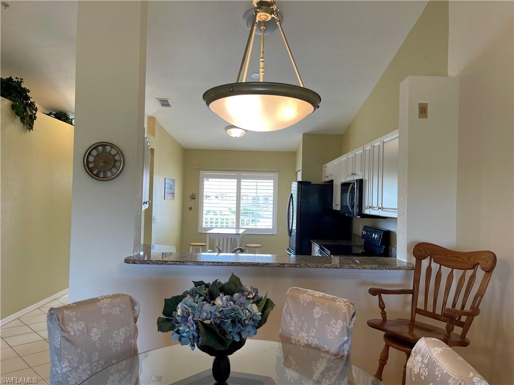 9009 Michael Circle, Unit 1110 Naples, FL 34113 - Photo 10 of 48 a living room with furniture and a chandelier