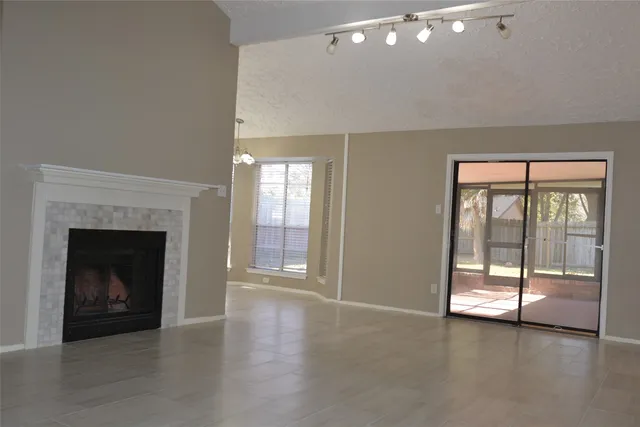 a view of an empty room with glass door and wooden floor