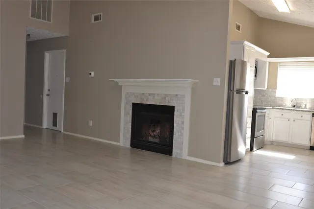a view of an empty room with a fireplace and a window