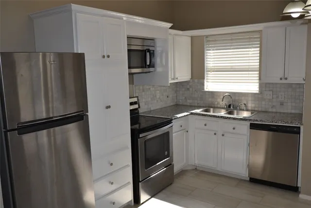 a kitchen with stainless steel appliances a refrigerator sink and microwave