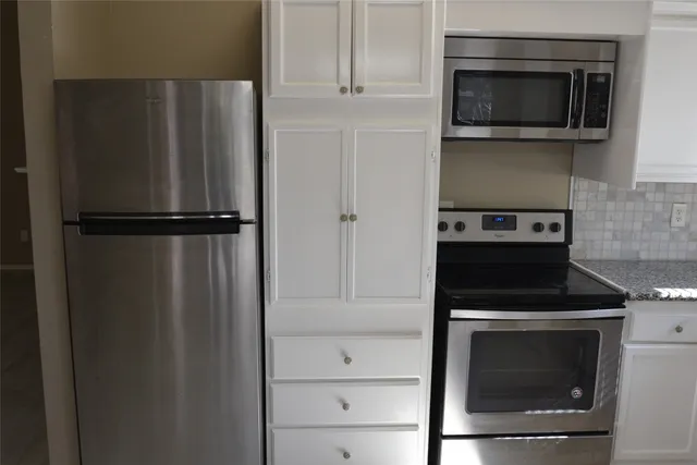 a kitchen with a refrigerator stove and microwave