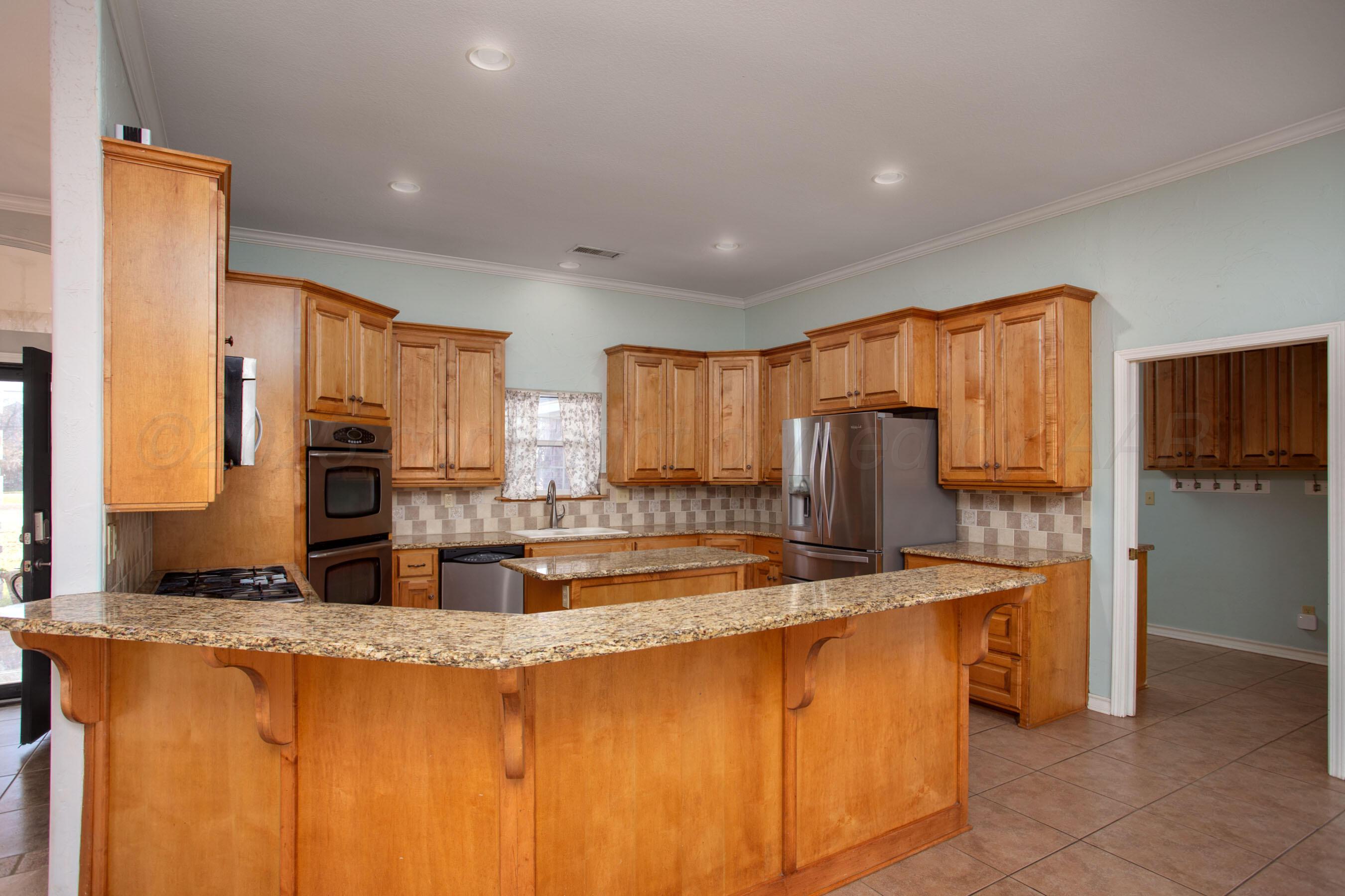 8900 Ottobahn Amarillo, TX 79119 - Photo 16 of 56 a kitchen with stainless steel appliances granite countertop a sink a stove and refrigerator