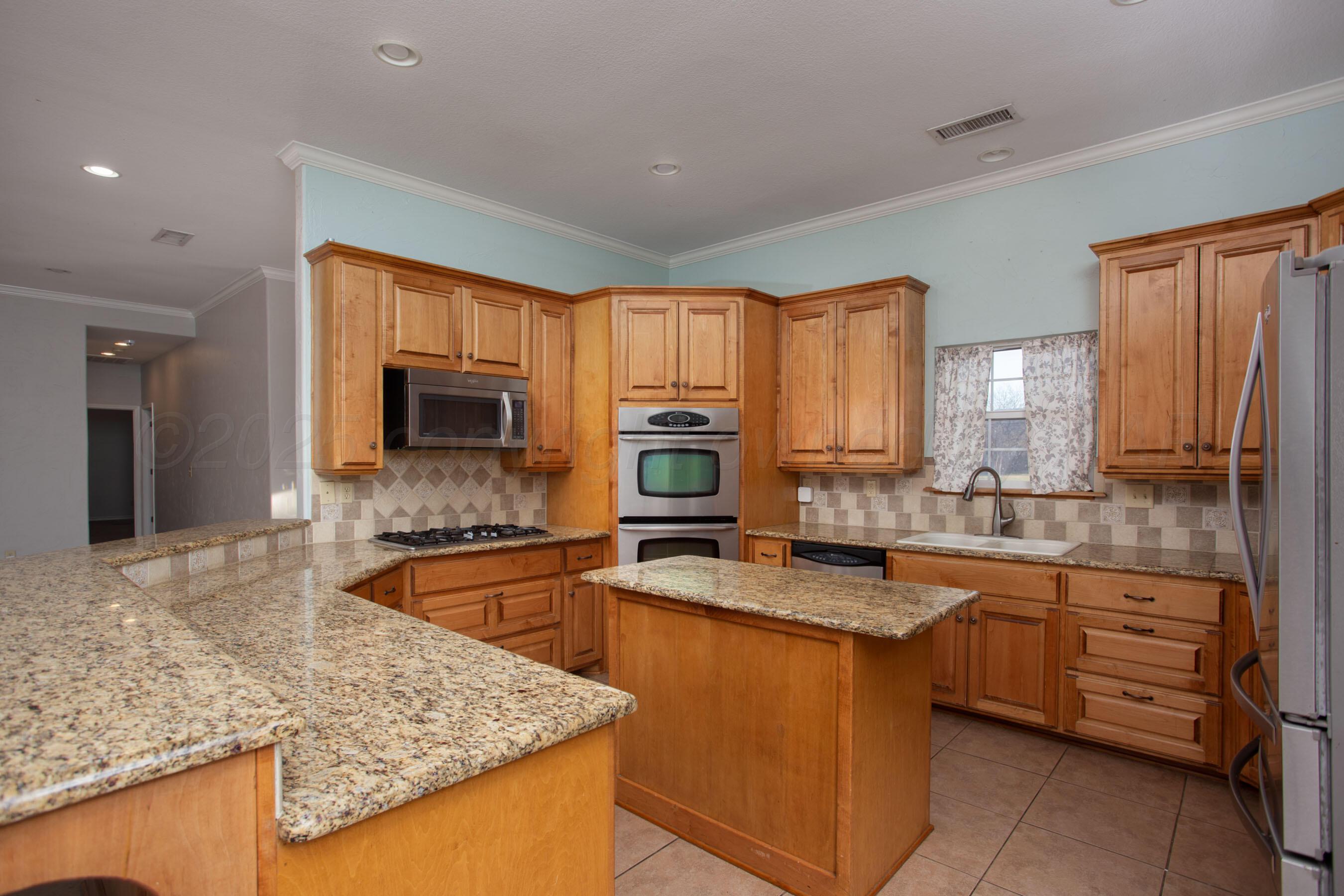 8900 Ottobahn Amarillo, TX 79119 - Photo 17 of 56 a kitchen with stainless steel appliances granite countertop a sink stove microwave and refrigerator
