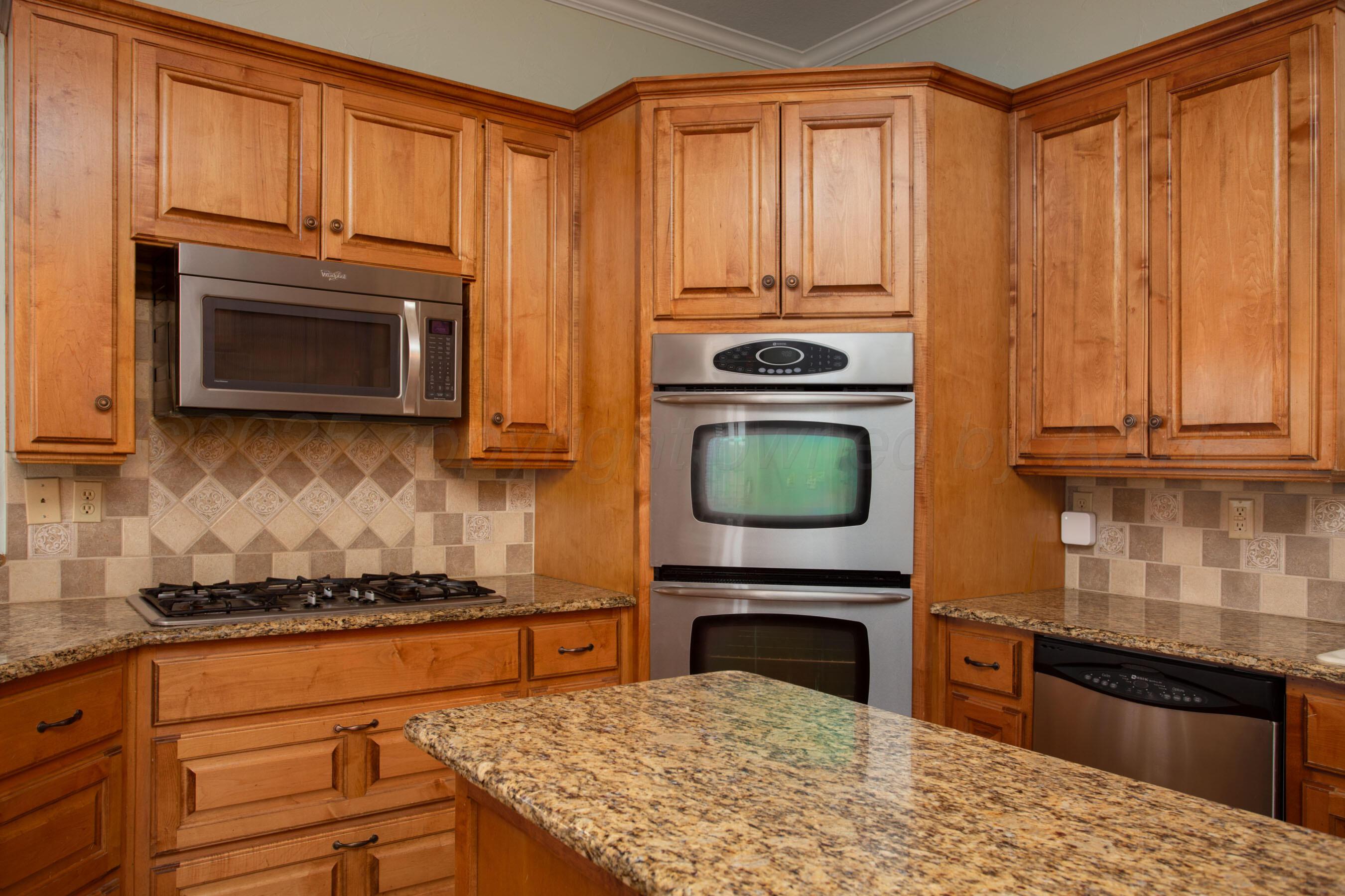 8900 Ottobahn Amarillo, TX 79119 - Photo 20 of 56 a kitchen with granite countertop a stove top oven microwave and cabinets