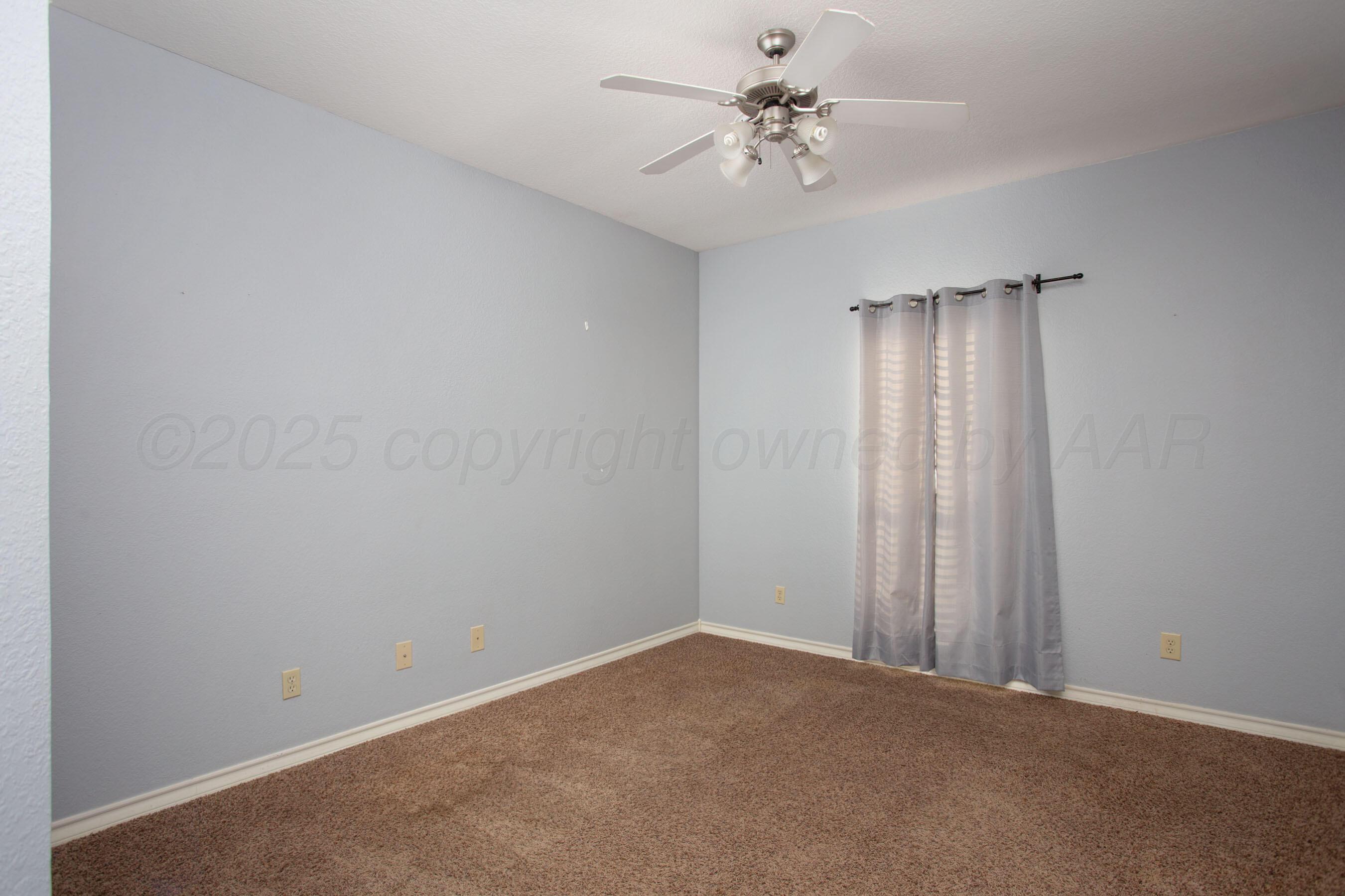 8900 Ottobahn Amarillo, TX 79119 - Photo 26 of 56 an empty room with a chandelier fan and windows