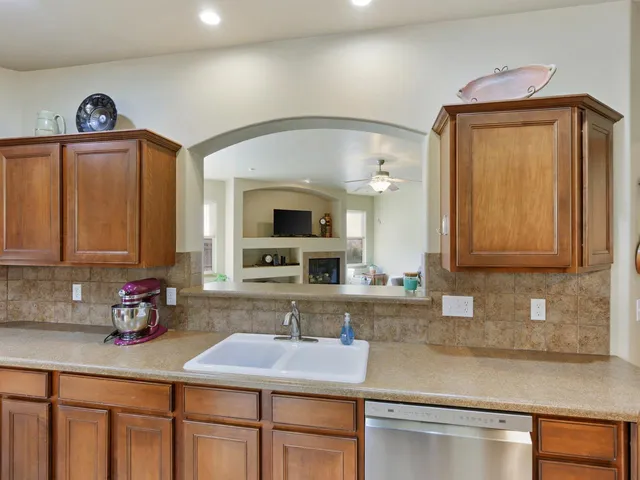 a kitchen with stainless steel appliances granite countertop a sink a stove and cabinets