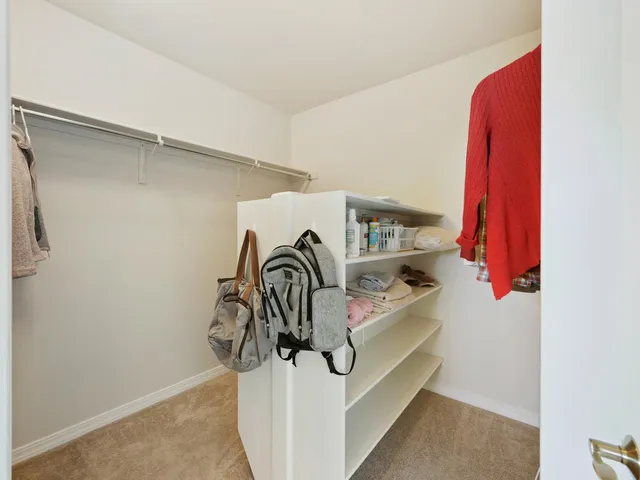a view of walk in closet with clothes and shoes