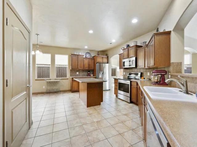a kitchen with stainless steel appliances granite countertop a stove top oven a sink a counter top space and cabinets