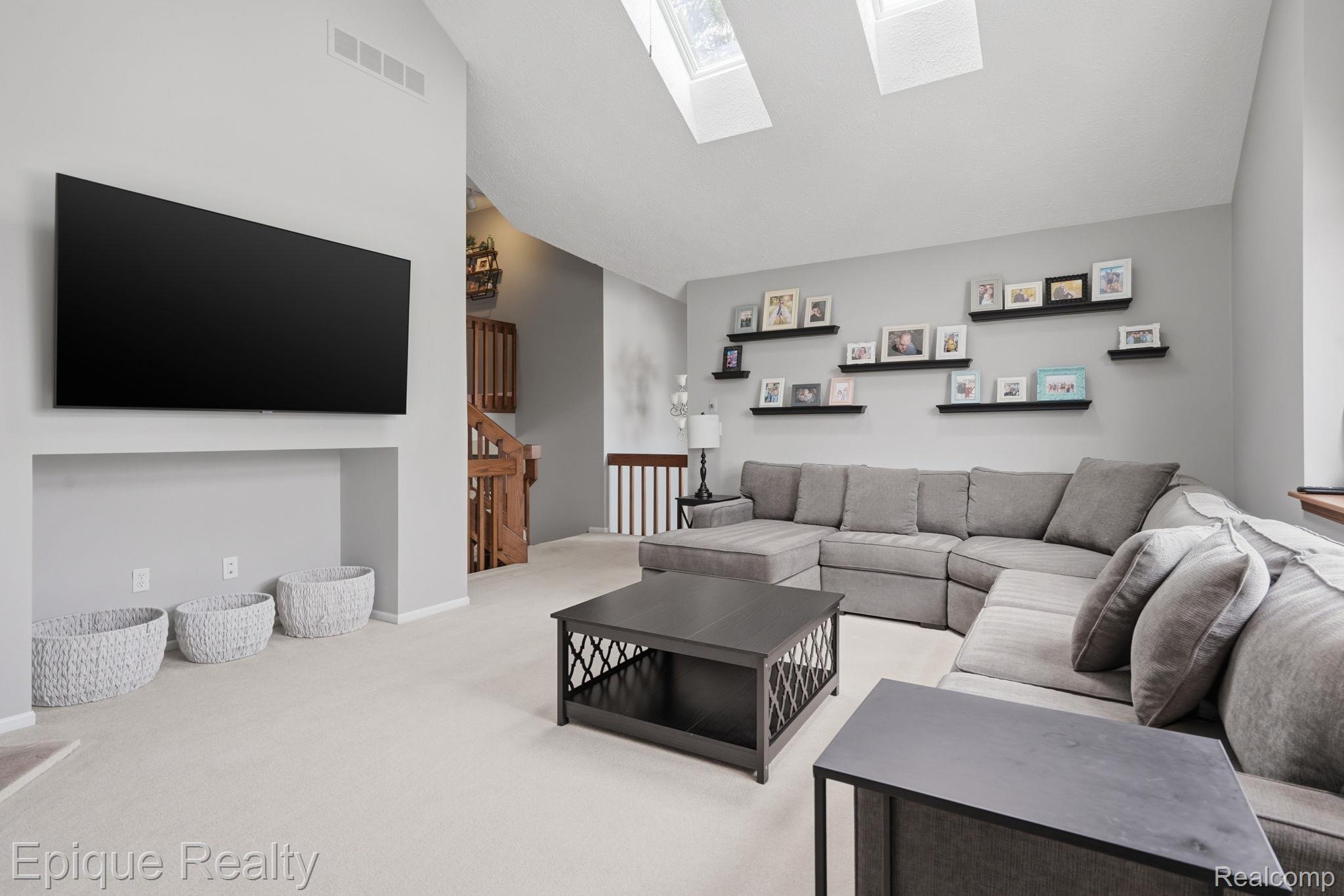 6607 Ridgeview Drive Clarkston, MI 48346 - Photo 10 of 25 Carpeted living room featuring a skylight and vaulted ceiling