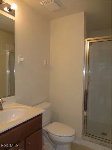 a bathroom with a sink a toilet a mirror and shower