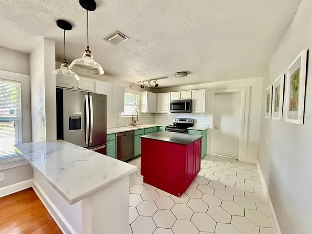 a kitchen with stainless steel appliances kitchen island granite countertop a refrigerator a stove a sink dishwasher with a dining table and chairs