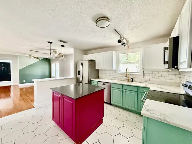 a kitchen with kitchen island granite countertop a sink counter top space and cabinets