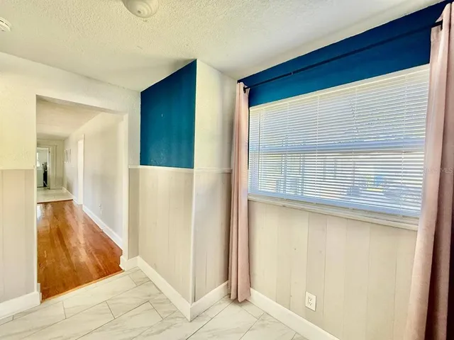 a view of a big room with wooden floor and a kitchen view