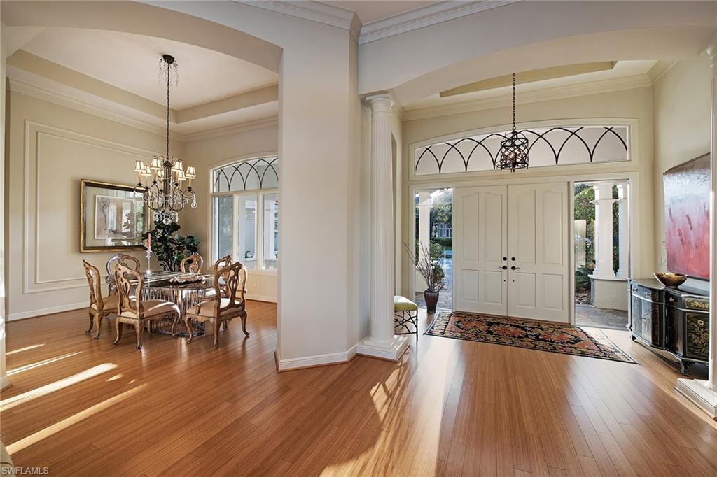 2618 Bulrush Lane Naples, FL 34105 - Photo 2 of 19 a view of a dining room and livingroom with furniture wooden floor a chandelier