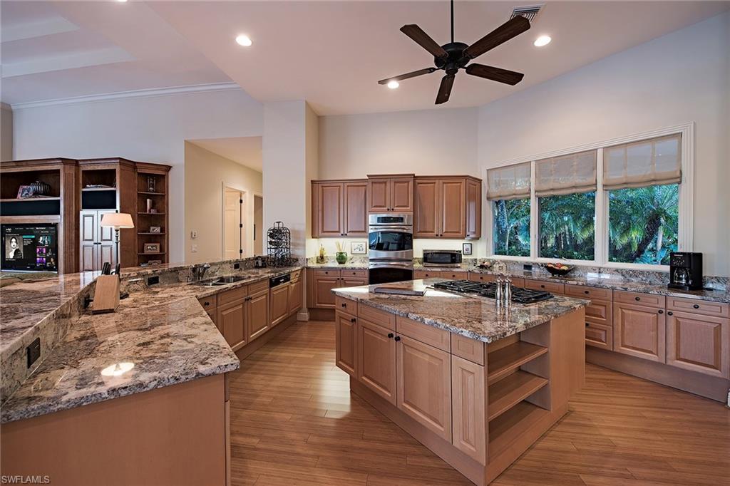 2618 Bulrush Lane Naples, FL 34105 - Photo 5 of 19 a large kitchen with stainless steel appliances granite countertop a stove top oven a sink and cabinets