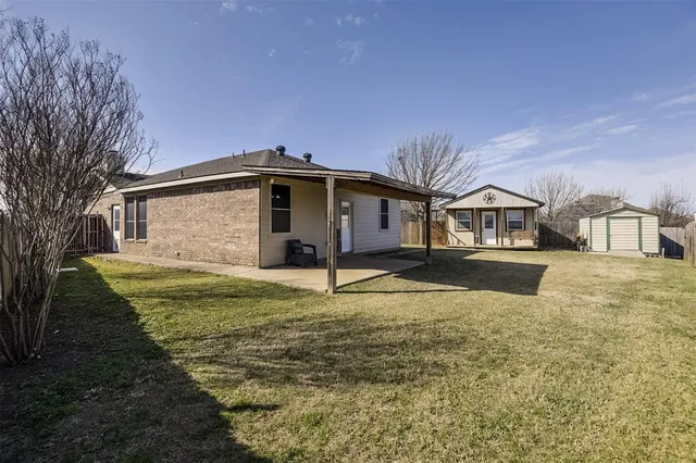 a view of a house with backyard and trees