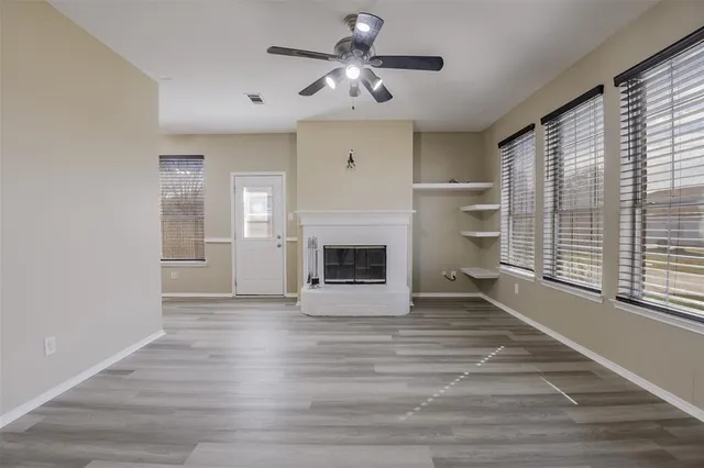 a view of an empty room with a fireplace and a window