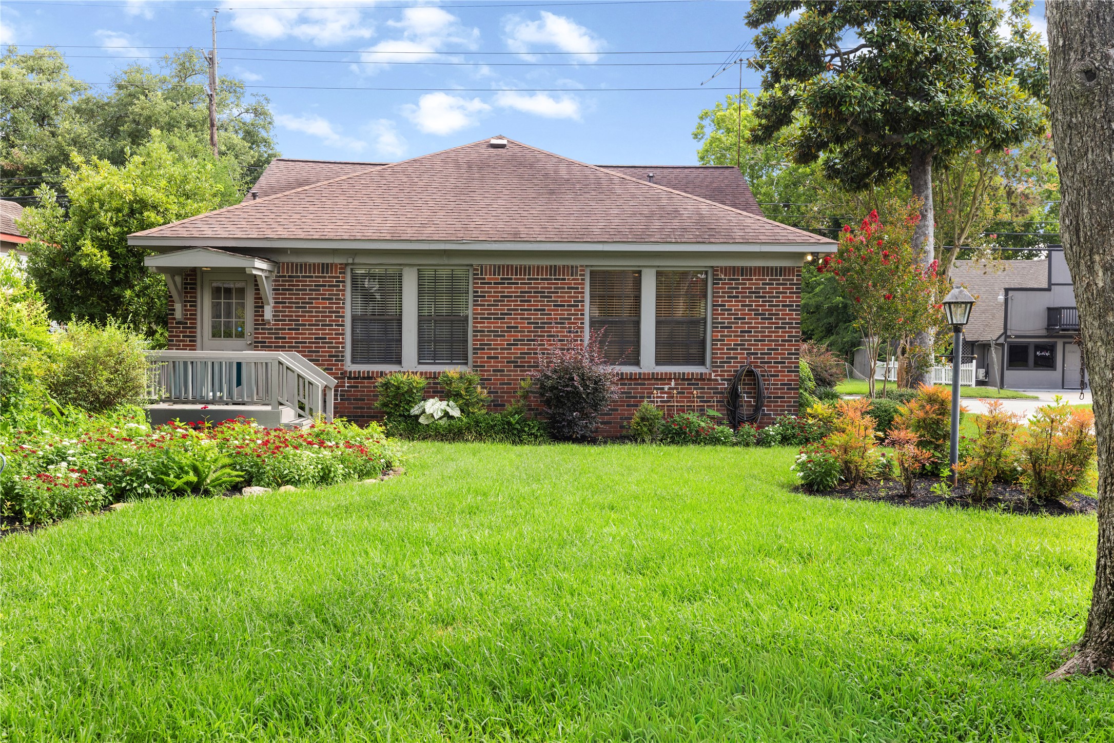 906 Higgins Street Humble, TX 77338 - Photo 7 of 26 Charming brick home with a well-maintained front yard, lush greenery, and a cozy porch. Ideal for buyers seeking a serene residential setting or extra parking for commercial use.